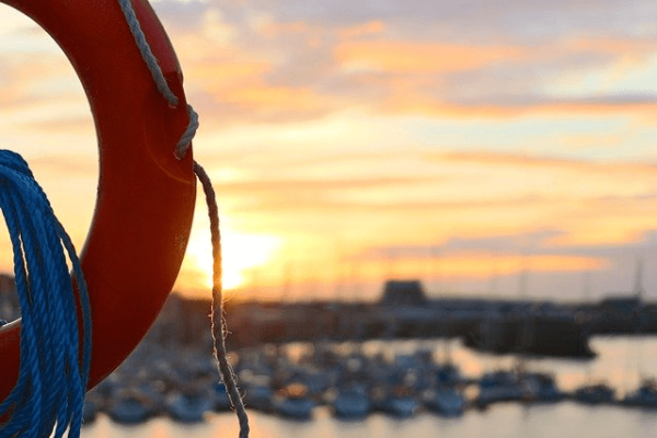 Orange lifebuoy and buoyant heaving line on an inflatable boat at a Canadian marina